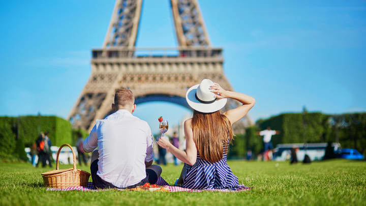 Couple having a picnic on the lawn by the Eiffel Tower