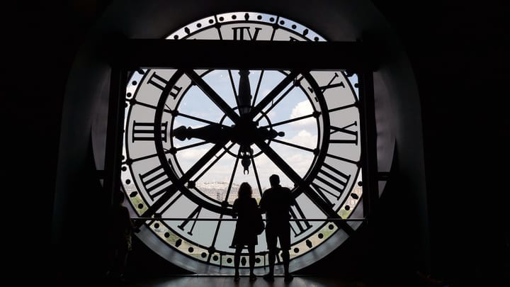 Tourists looking through the famous clock face at the Musée d'Orsay in Paris