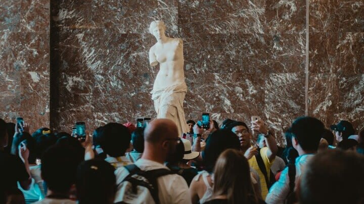 Tourists viewing the Venus de Milo in the Louvre, Paris